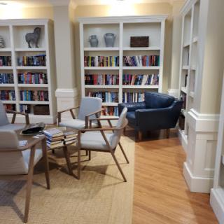 A cozy reading nook featuring comfortable chairs and bookshelves filled with books.