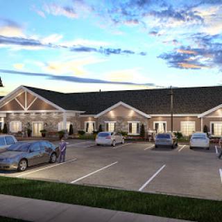 A modern residential building with a spacious parking lot during sunset.