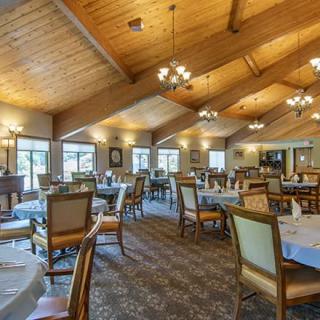 A spacious dining area with elegant furnishings and warm lighting.