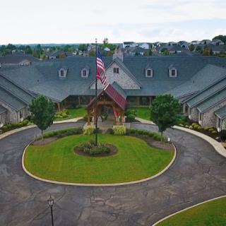 An aerial view of a large building with a circular driveway and an American flag at the entrance.