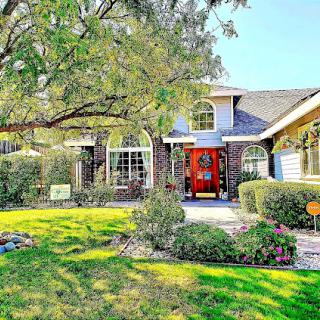 A charming residential home with a vibrant front yard and welcoming entrance.