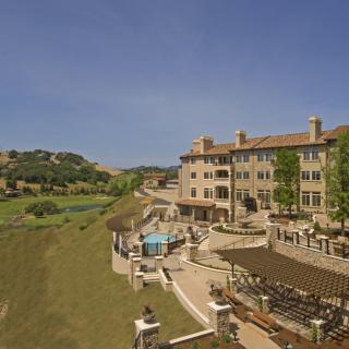 A luxurious resort hotel with a pool and scenic landscape view.