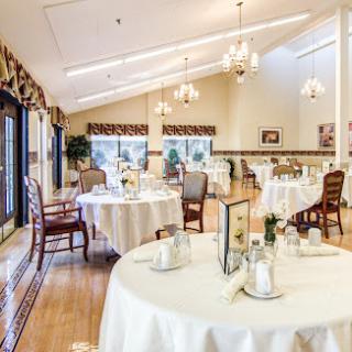 An elegant dining area featuring well-set tables, inviting natural light, and a warm ambiance.