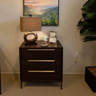 A stylish nightstand with a modern lamp and artwork above, creating a cozy interior design setup.