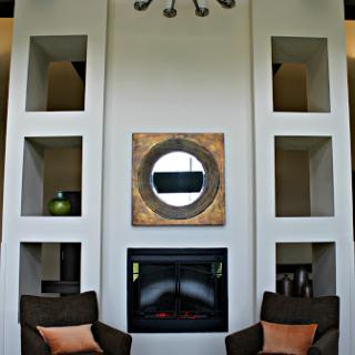 A modern living room featuring an elegant fireplace, stylish shelving, and comfortable seating.