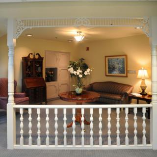 A cozy living room setup featuring a sofa, coffee table with floral centerpiece, and ambient lighting.