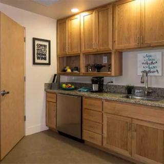 A modern kitchen featuring wooden cabinets and a granite countertop.