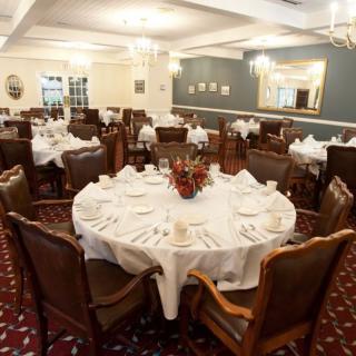 A formal dining room with elegantly set tables, ready for an event.