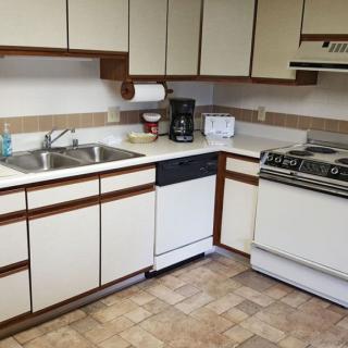 A classic kitchen setup featuring a stove, dishwasher, and cabinets.