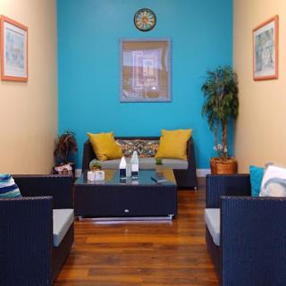 A cozy and modern waiting area featuring comfortable seating and vibrant blue walls.