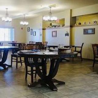 An empty restaurant dining area with tables and chairs neatly arranged.