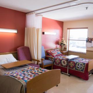 A clean and comfortable hospital room with two patient beds, designed for a welcoming atmosphere.