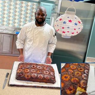A chef proudly presents a freshly baked cake in the kitchen.