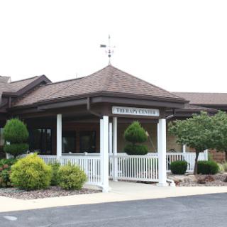 A welcoming entrance to a well-maintained building surrounded by lush greenery.