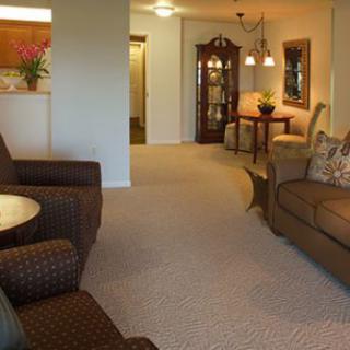 A cozy living room with comfortable seating and a dining area in the background.