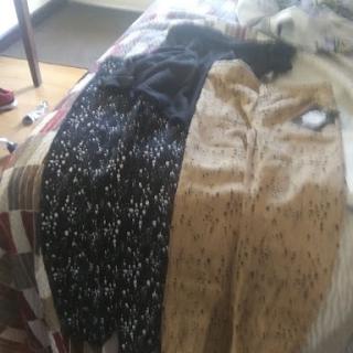A variety of clothing laid out on a bed, featuring different patterns.