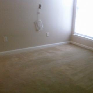 An empty room with carpet flooring and a window.