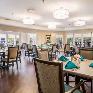 A spacious dining room with elegantly set tables and comfortable chairs.