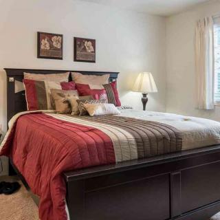 A cozy bedroom with a neatly made bed and warm decor.