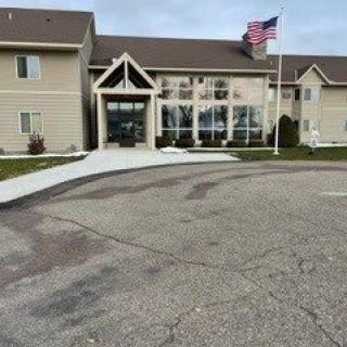 A building entrance with an American flag and surrounding pavement.