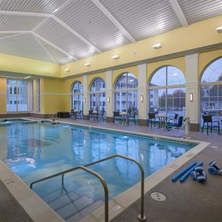 An indoor swimming pool with large windows and a spacious interior, designed for relaxation and fitness.