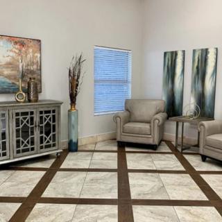 A cozy living room with elegant armchairs, artwork, and decorative elements.