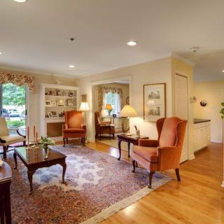 A cozy and traditionally decorated living room with comfortable armchairs, a coffee table, and soft lighting.