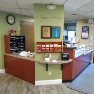 A welcoming reception area of a medical office, featuring a desk, waiting space, and decorative elements.