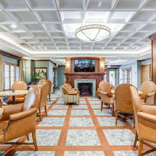 A luxurious lounge area with comfortable seating, featuring a fireplace and elegant lighting.