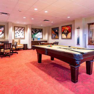A stylish game room featuring a billiards table and vibrant artwork.
