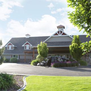 A scenic view of a large building surrounded by trees and greenery under a blue sky.