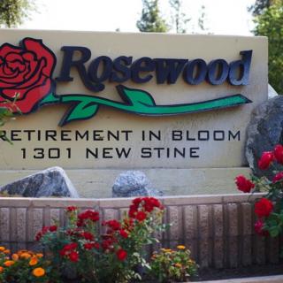 Entrance sign for Rosewood Retirement Home surrounded by vibrant flowers.