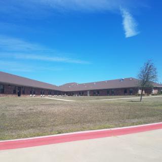 A view of a school building set against a clear blue sky.