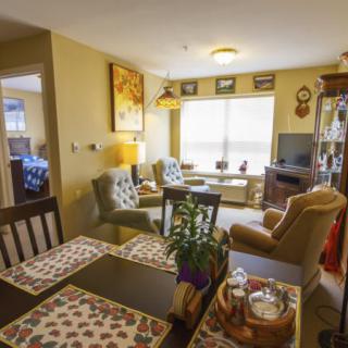 A cozy living room with a dining area, featuring comfortable furniture and warm decor.