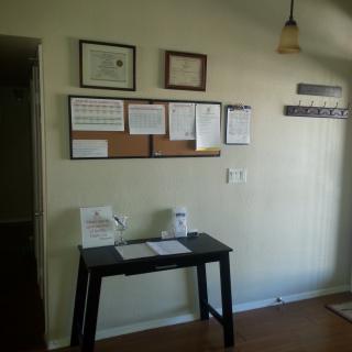 A tidy office corner featuring a desk and wall-mounted certificates.