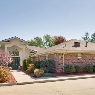 A charming suburban house with brick exterior and well-maintained landscaping.