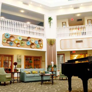 A stylish hotel lobby with a grand piano and colorful decor.
