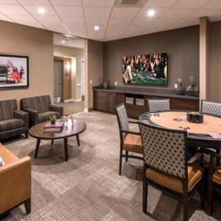 A comfortable lounge area with seating and a poker table in a professional setting.