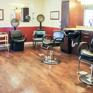 A cozy hair salon with styling chairs, mirrors, and hair dryers.