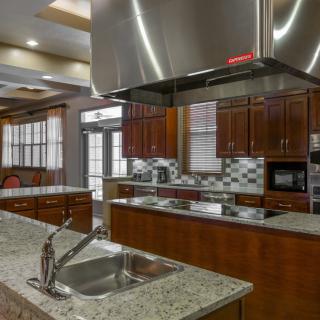 A modern kitchen with granite countertops, stainless steel appliances, and elegant wood cabinetry.