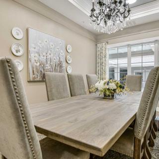 A beautifully decorated dining room with a wooden table, elegant chairs, and a chandelier.