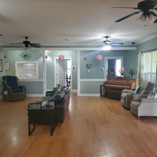 Spacious living room with seating area and wooden floors.