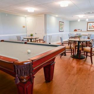A cozy game room featuring a billiards table and seating area.