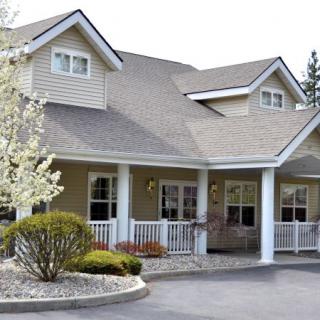 A suburban house with a porch and landscaped front yard.