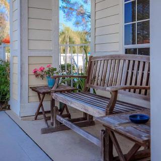 A cozy porch with wooden furniture and a small table adorned with flowers.