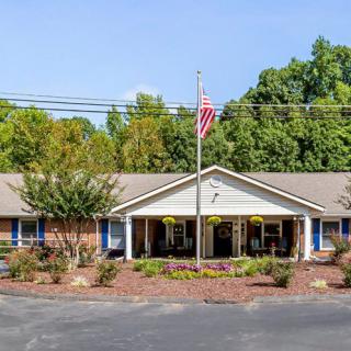 A single-story building with a landscaped front and an American flag flying overhead.