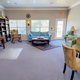 A cozy living room with comfortable seating, bookshelves, and plenty of natural light.