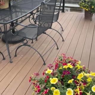 A cozy patio setting with metal furniture and vibrant potted flowers.