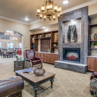 A cozy living room with a fireplace and elegant chandelier.