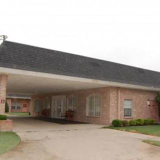 A single-story brick building with a covered entrance and driveway.